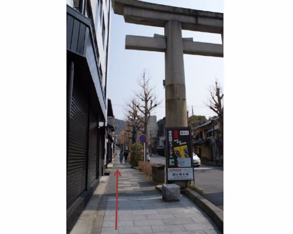 The sloping lane rising to the left of the torii gateway