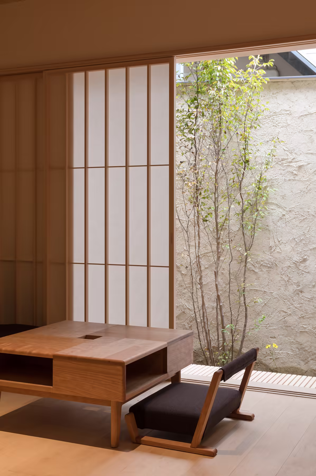 A tatami sitting room in a Kyoto machiya, paper screens open to the garden