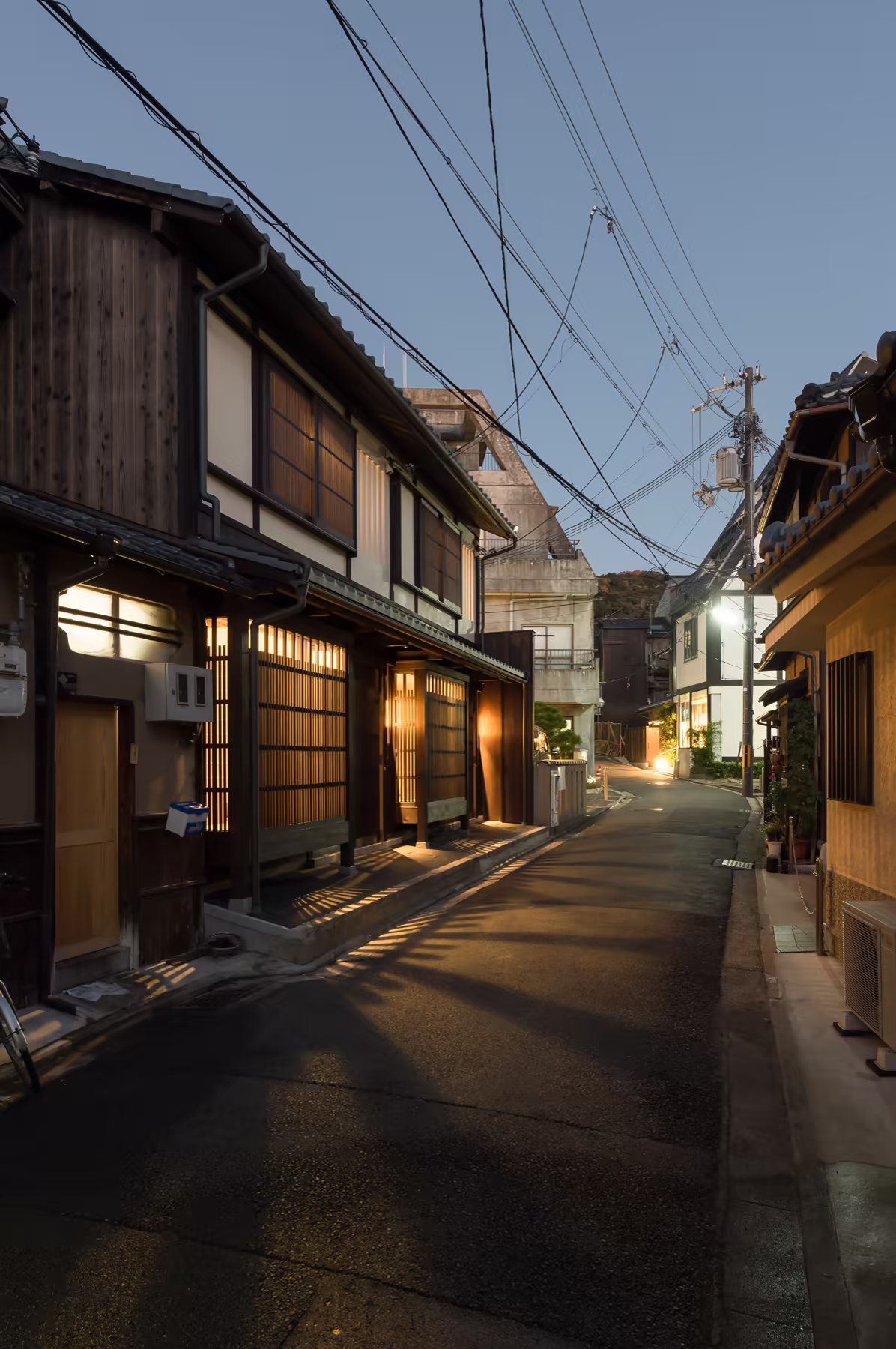 The lane at dusk in Higashiyama, Kyoto, the machiya fronts lit along it
